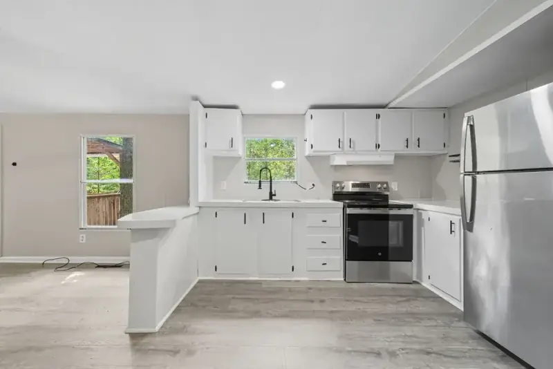 Bright white kitchen with stainless steel appliances at 330 Hyde Road