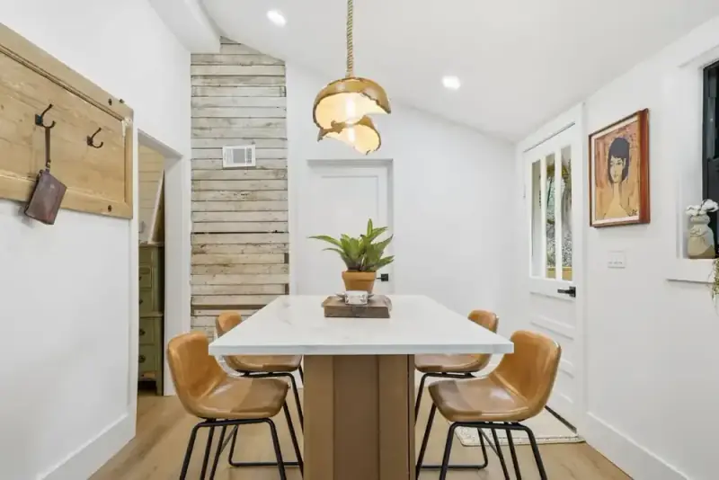 Dining area at 356 Hyde Road with a wood table, pendant lights, and a view into the kitchen