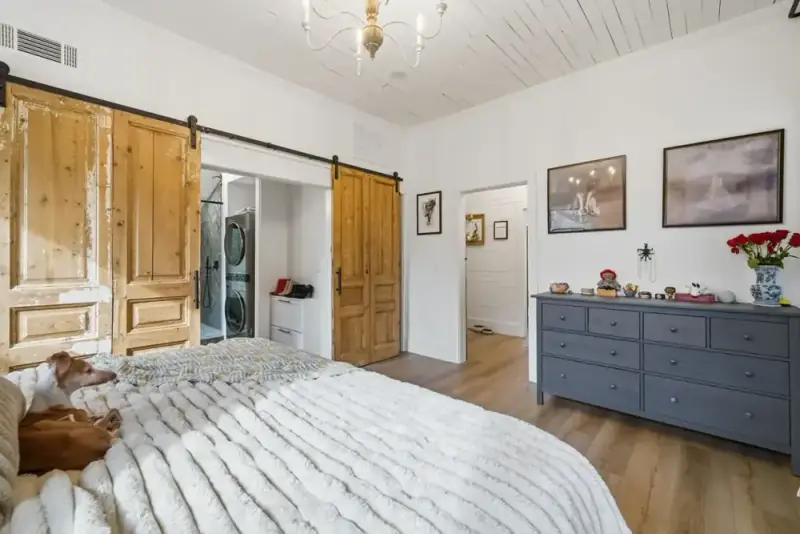 Bedroom at 356 Hyde Road with a bed, wood dresser, chandelier, and bright windows