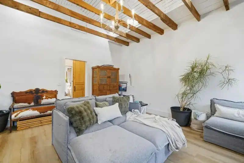 Living area at 356 Hyde Road with sofas, exposed wood beams, and a view toward the fireplace