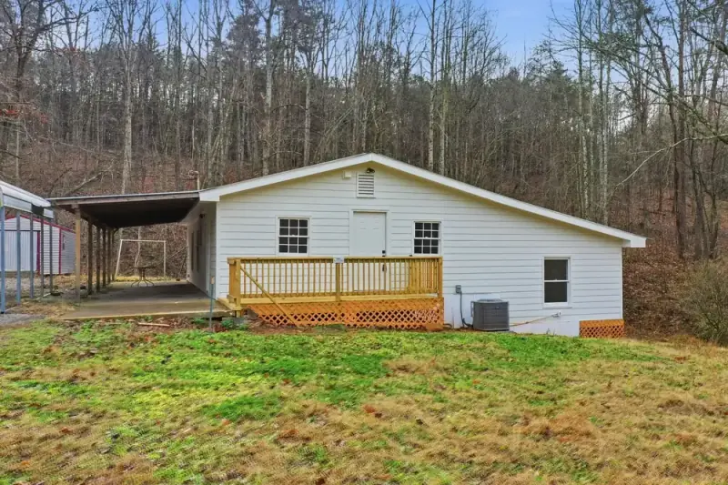 White rental home with a covered porch in the woods at 6757 Henderson Mtn in Jasper